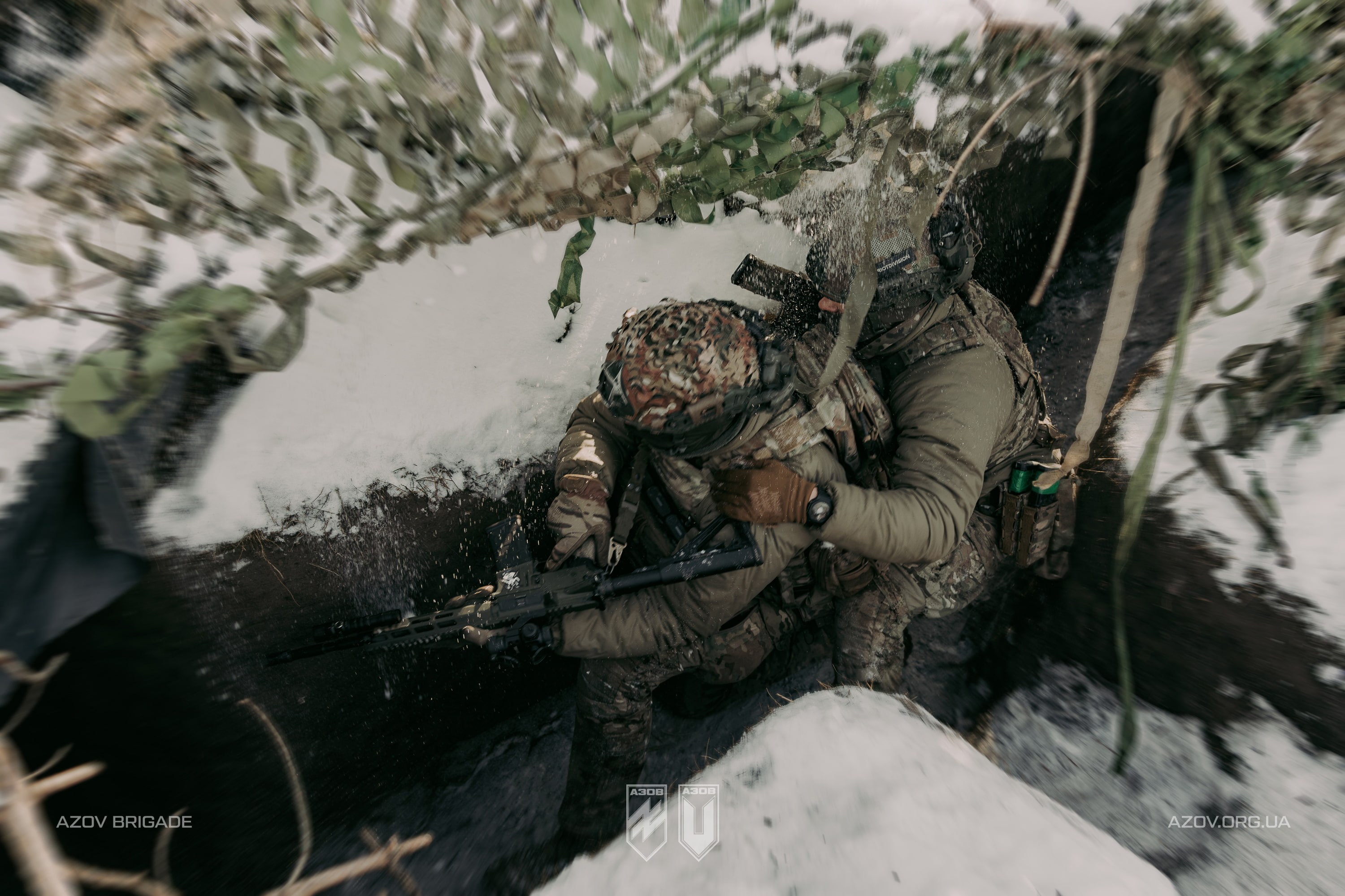 Двоє військових у траншеї з автоматами під час бойового чергування