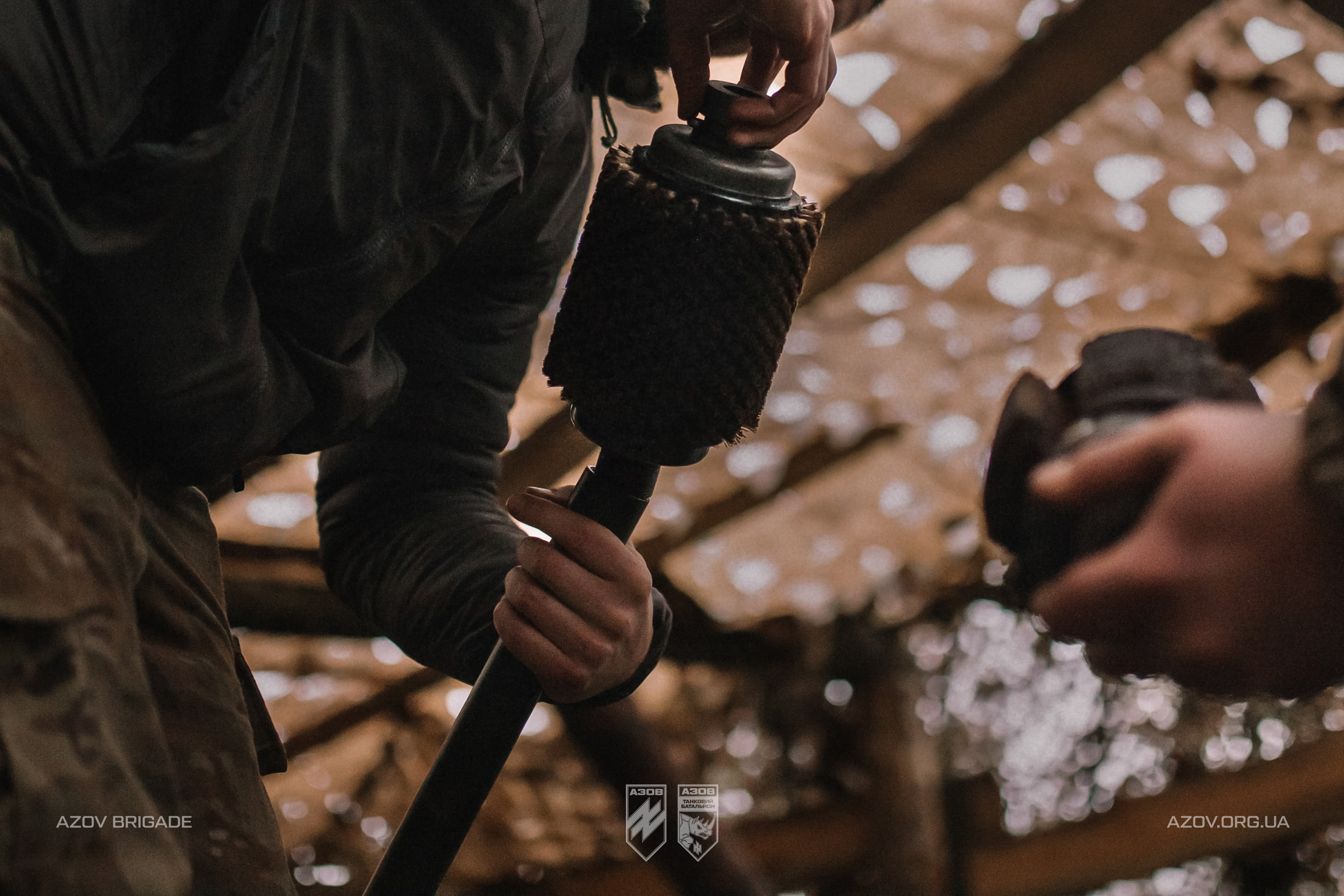 Боєць очищає елемент артилерійської гармати перед використанням