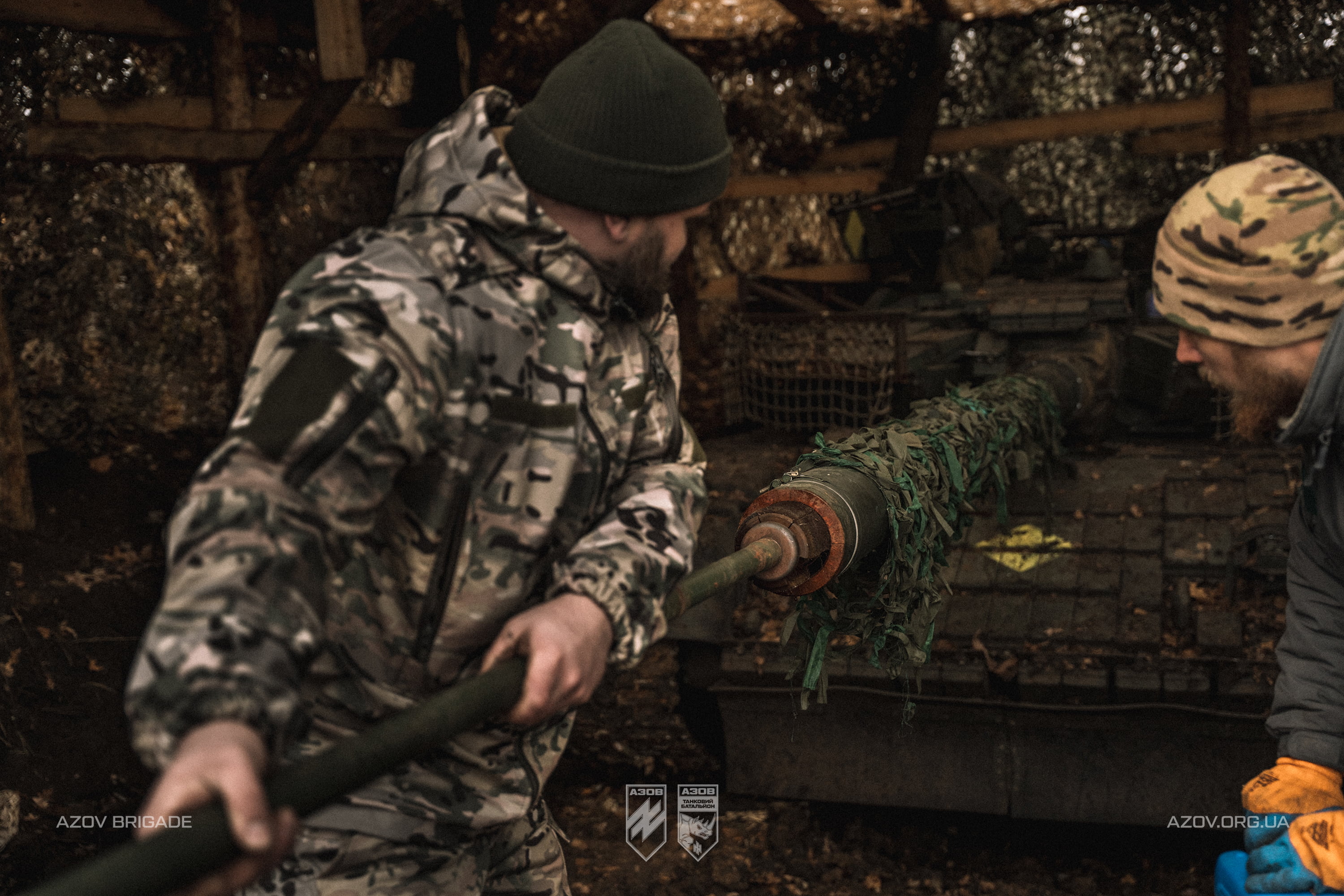 Артилеристи заряджають гармату на замаскованій позиції