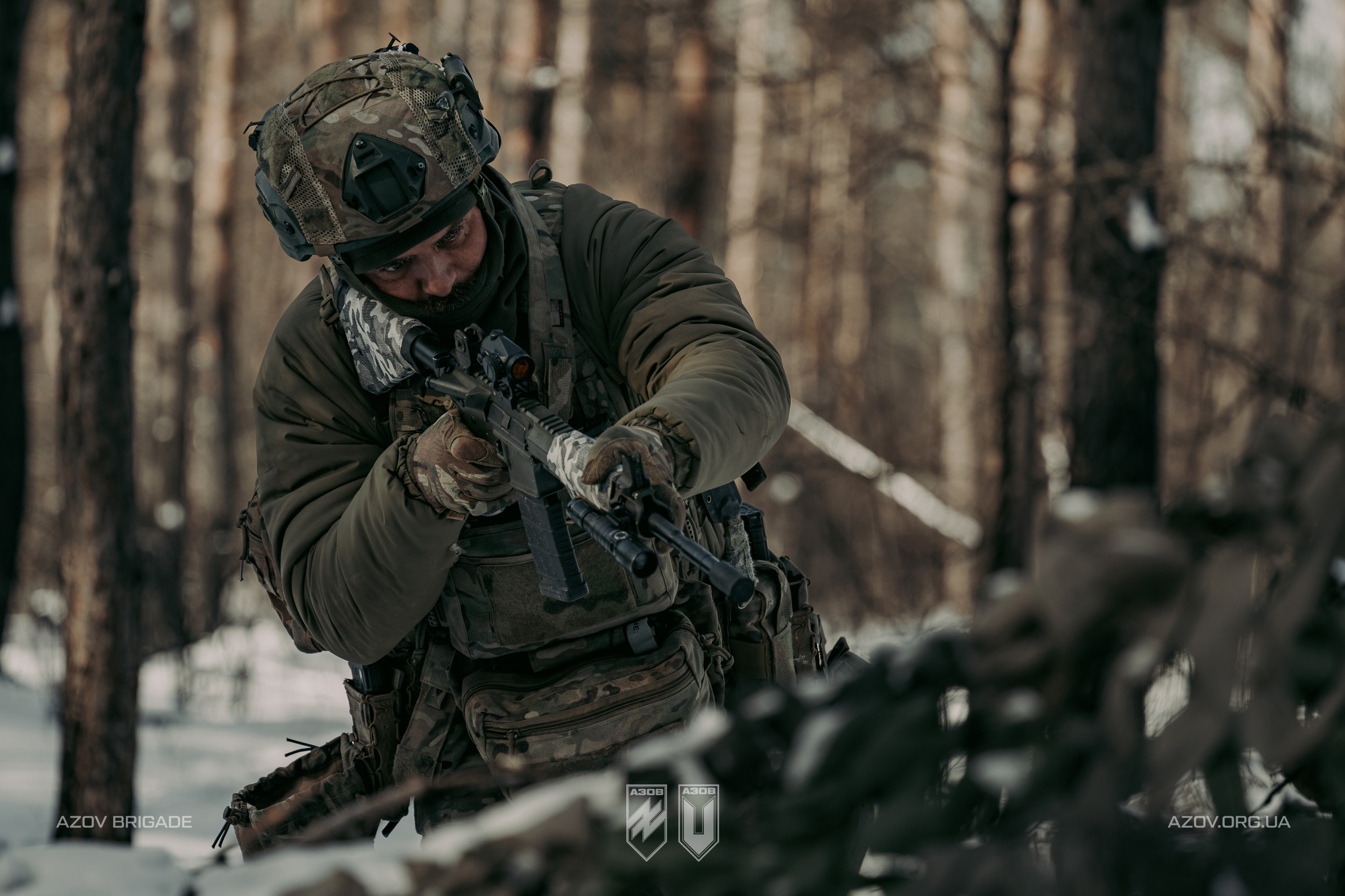 Боєць із автоматом на вогневій позиції серед зимового лісу