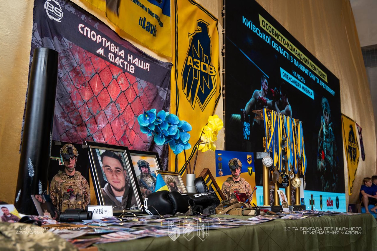 Меморіальний стенд загиблого бійця з фотографіями, нагородами та символікою «Азов» під час турніру пам’яті